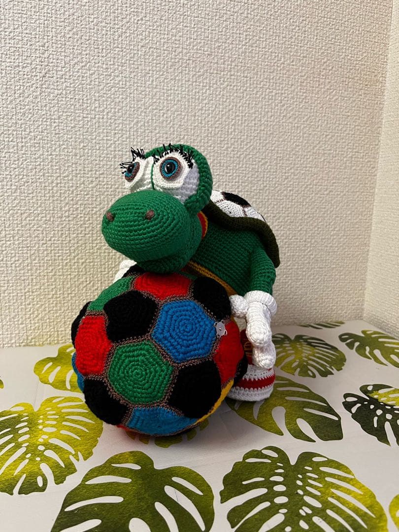 サッカーボールを持つ編み物カメのぬいぐるみ