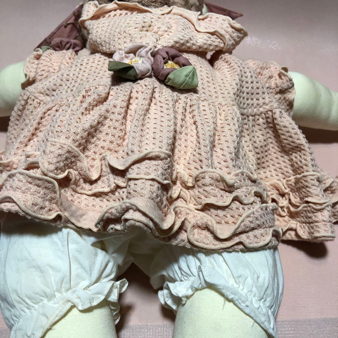 ポテチーノピンクの服を着た三つ編みのお人形の女の子